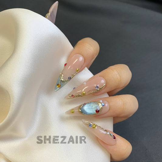 Vintage gold gemstone stiletto press-on nails worn on hand