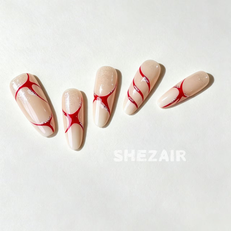Red star ribbon almond press-on nails with nude base and silver glitter accents by Shezair