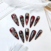 Crimson Widow burgundy gothic stiletto press-on nails styled with white feathers
