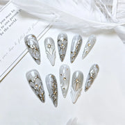 Silver Eclipse grey chrome stiletto press-on nails styled with white feathers
